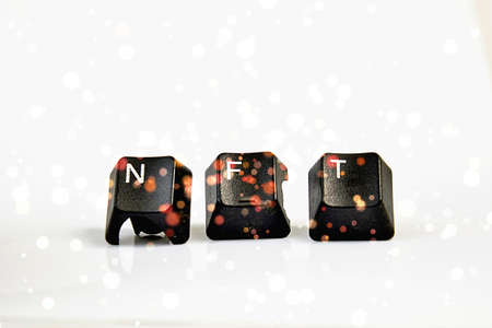 NFT text with used black computer keys on white.の写真素材