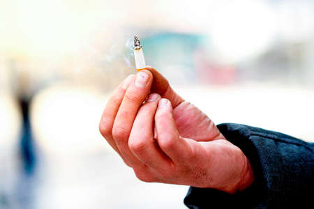 Hand hold the cigarette with smoke .addiction issues.の写真素材