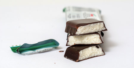 Chocolate Protein bar filled with chocolate sauce, cut on a white background