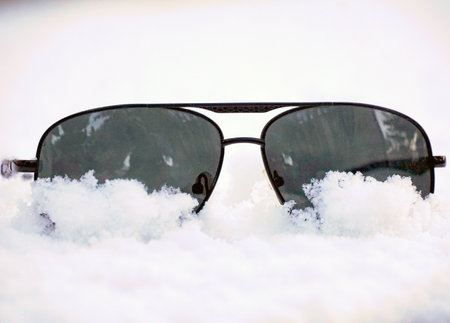 trendy glasses lie on the snow. winter theme concept.の写真素材