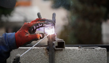 welder is welding metal part on a construction site .の写真素材