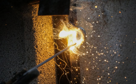 welder is welding metal part on a construction site .