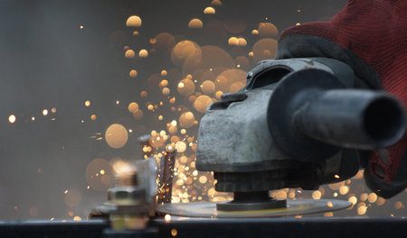 Metal processing with grinder. cutting metal on location of conctruction site, Sparks in metalworking.の写真素材