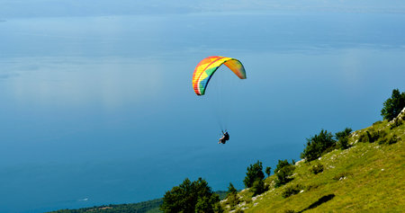 Tandem Paraglider flying over the Lake Ohrid in soutwest of macedonia.の写真素材