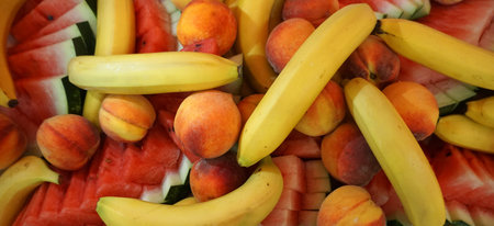 Fresh ripe fruits, peaches, bananas and slieces of watermelon on a plate. Healthy food conceptの写真素材