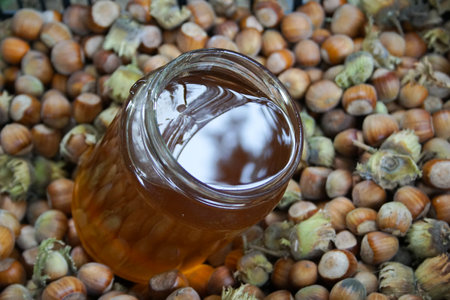 Honey in glass jar and fresh harvested organic hazelnuts,Natural organic products concept.の写真素材