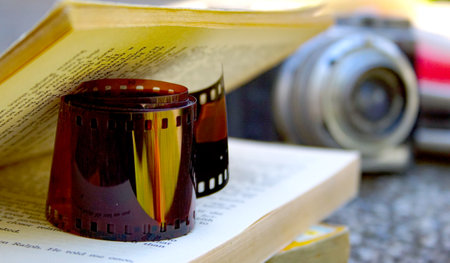 Roll of developped 35 mm coloured film between book pages