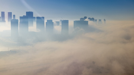 Skylines under the thick fog at the street timelapse of Abu Dhabi at morning, the biggest and most populated city of United Arab Emirates. Aerial view of skyscrapers from above after sunriseの写真素材