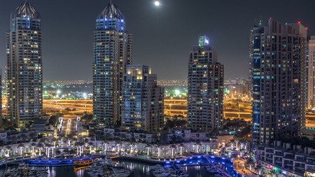 Dubai Marina at night timelapse, Glittering lights and tallest skyscrapers. Illuminated towers and traffic on the road on background. Rising Moon on the skyのeditorial素材