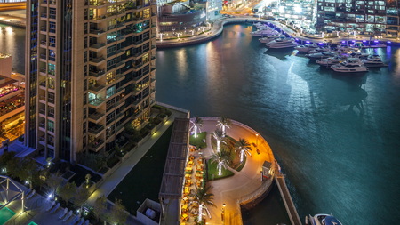 Tallest skyscrapers in Dubai Marina at night timelapse, Glittering lights and evening illumination. Traffic on the road and palms on promenadeのeditorial素材