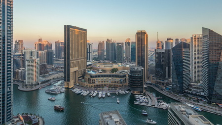 Sunset view of Dubai Marina evening aerial timelapse, UAE. Modern skyscrapers and residential buildings with orange light. Yachts and boats near shoping mall on artificial canal cityのeditorial素材