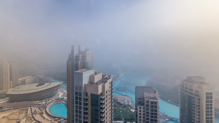 Foggy morning in downtown of Dubai timelapse during all day. Futuristic view of the city skyscrapers...