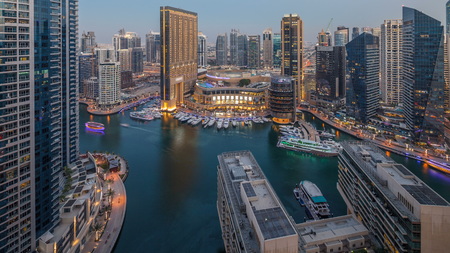 Evening illumination of Dubai Marina day to night transition aerial timelapse, UAE. Modern skyscrapers and residential buildings. Yachts and boats near shoping mall on artificial canal cityのeditorial素材