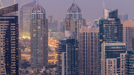Beautiful aerial top view day to night transition timelapse of Dubai Marina after sunset in Dubai, UAE. Modern towers and traffic on the road.の写真素材