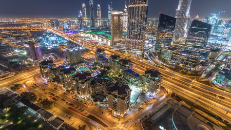 Dubai downtown skyline night timelapse with mall and highway road traffic, UAE. Aerial view from rooftop of skyscraper with illuminated modern towersのeditorial素材