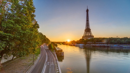 Eiffel Tower and the Seine river at Sunrise timelapse, Paris, France. Morning view from Bir-Hakeim bridge with reflections on water and traffic on the streetの写真素材