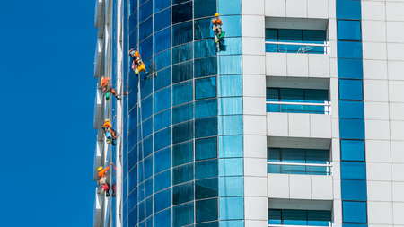 Washers wash the windows of modern skyscraper in Dubai timelapse, UAE. Close up view at sunny day