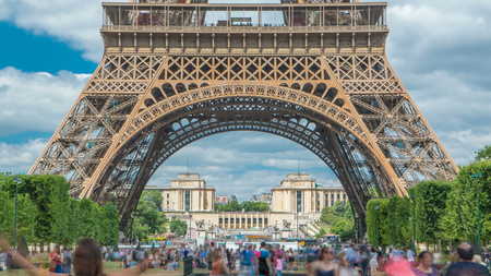 Champ de Mars and the Eiffel Tower timelapse in a sunny summer day. Paris, France. Green trees and cloudy sky, people walking aroundの写真素材