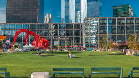 Skyscrapers of La Defense and green lawn with benches timelapse - Modern business and residential area in the near suburbs of Paris, France. Green trees, blue cloudy sky at sunny summer dayの写真素材