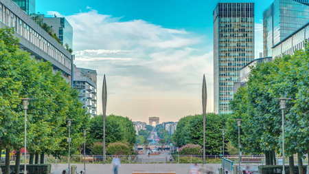 Skyscrapers of La Defense timelapse - Modern business and residential area in the near suburbs of Paris, France. Arc de Triomphe with Champs Elysees on background. Green trees, blue cloudy sky at sunny summer dayの写真素材