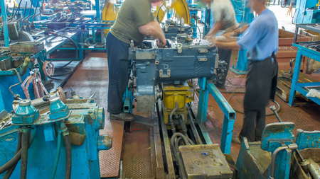 Tractor engine assembled on the factory production line on tractor factory timelapse. Workers in...