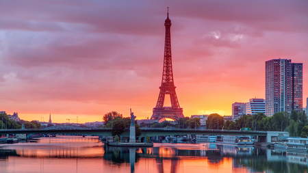 Eiffel Tower sunrise timelapse with boats on Seine river and in Paris, France. View from Mirabeau...