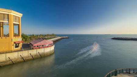 Boats passing to harbor at the Sharq Marina morning timelapse after sunrise in Kuwait. Kuwait City,...