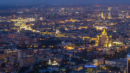Aerial top view of Moscow night timelapse after sunset. Form from the observation platform of the business center of Moscow City. Illuminated stalin skyscrapers and traffic on roadの写真素材