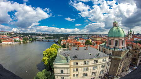 view of the manes bridge with a building of the czech parliament behind it, traditional red roofs...