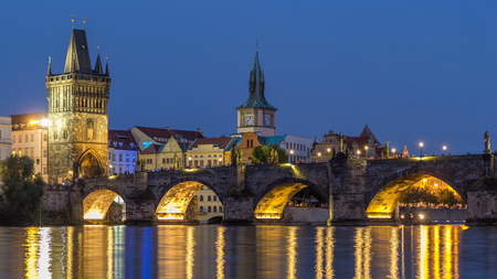The Charles Bridge day to night transition timelapse over the Vltava River reflected in water in...