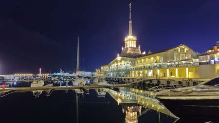 Marine station in Sochi timelapse hyperlapse at night with reflection in the sea with ship and yacht 4Kの写真素材