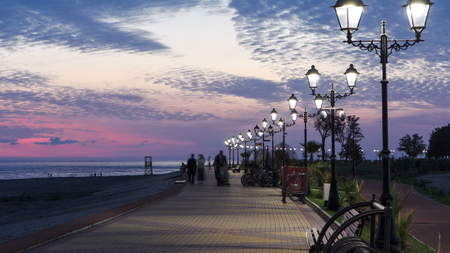 Sea embankment road street  timelapse hyperlapse cloud day to night transition with lights turn on Sochi Russiaの写真素材