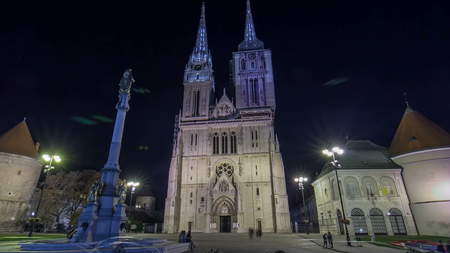 Entrance to Zagreb Cathedral night timelapse hyperlapse and Monument called Maria's pillar. ZAGREB, CROATIA. Blue sky at sunny day, people walk aroundの写真素材