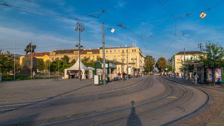 New modern trams of Croatian capital Zagreb timelapse near railway station. People at tram stop at...