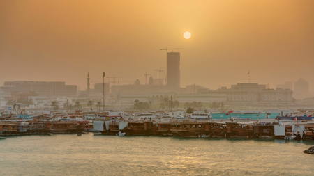 Sunset at Doha Bay timelapse with Traditional Wooden Dhow Fishing Boats. View from museum with...