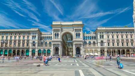 The Galleria Vittorio Emanuele II timelapse hyperlapse on the Piazza del Duomo (Cathedral Square). This gallery is tourist attraction of Milan. Blue cloudy sky at summer day. People walking on the squareのeditorial素材