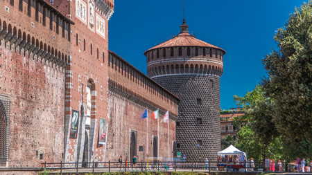 Main entrance to the Sforza Castle and tower - Castello Sforzesco timelapse, Milan, Italy. Blue sky at summer day. People walking around. Side viewのeditorial素材