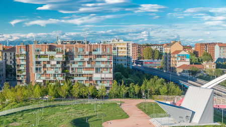 Modern buildings and park in the new area of Portello timelapse, Milan, Italy. Top view with traffic on the road. Blue cloudy sky at summer day.の写真素材