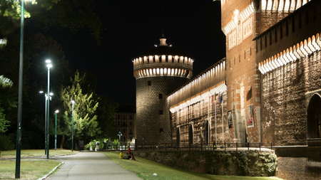 Main entrance to the Sforza Castle and tower - Castello Sforzesco illuminated at night timelapse, Milan, Italy. Side viewのeditorial素材