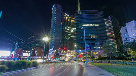 MILAN, ITALY - CIRCA JULY 2017: Milan skyline with modern skyscrapers in Porta Nuova business district night timelapse in Milan, Italy. Traffic on the road. Light in windows. View from roadのeditorial素材