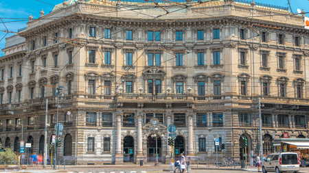 Cordusio Square Palace of the Italian Credit timelapse in Italian capital of fashion and luxury. Trams passing by. Blue sky at summer dayのeditorial素材