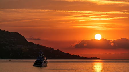Sunrise view of sea and landscape timelapse from Beaulieu sur mer, France. Boats and yachts on foreground. Reflections on water.の写真素材