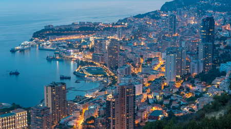 Aerial top view of Monaco from the grand corniche road day to night transition timelapse, Monaco France. Evening illumination. Reflections in water of harborの写真素材