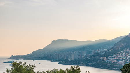 Cityscape timelapse of Monte Carlo, Monaco during summer sunset. Rays of setting sun with evening mist. Yachts on harbor. Top view from Cap Martinの写真素材