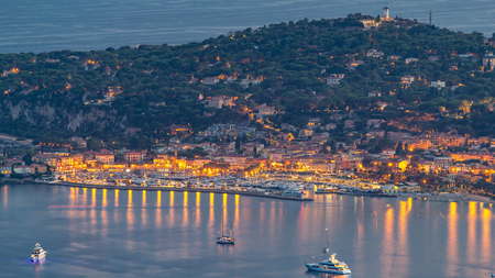 Yachts in port of Saint-Jean-Cap-Ferrat day to night transition timelapse - resort and commune in southeast of France on promontory of Cote d'Azur in Provence-Alpes-Cote d'Azur region, France. From the top of Eze villageの写真素材