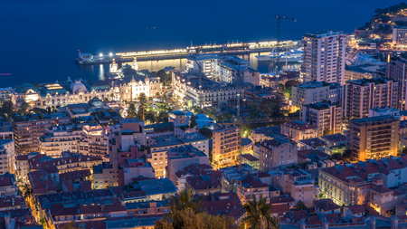 Cityscape of Monte Carlo, Monaco day to night transition timelapse with roofs of buildings and casino square after summer sunset. Aerial top view from hills.の写真素材