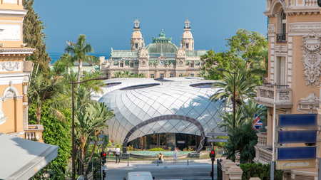 Water fountain and gardens timelapse, in front of the Monte-Carlo Casino. Traffic on the street. Blue cloudy sky at summer dayの写真素材