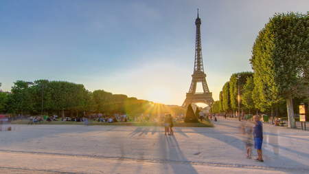 Eiffel Tower seen from Champ de Mars at sunset timelapse, Paris, France. People sitting on lawn. Summer evening with clear skyの写真素材