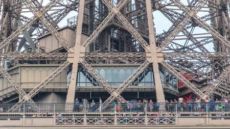 Close up view of first section of the Eiffel Tower with tourists on observation deck timelapse in...