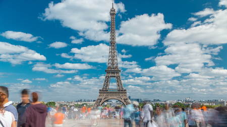 People walk on famous square Trocadero with Eiffel tower in the background timelapse. Trocadero and Eiffel tower are the most visited attractions of Paris. Blue cloudy sky at summer dayの写真素材